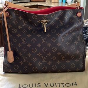 Louis Vuitton Gaia Hobo tote in monogram print with red cerise accent on sides.